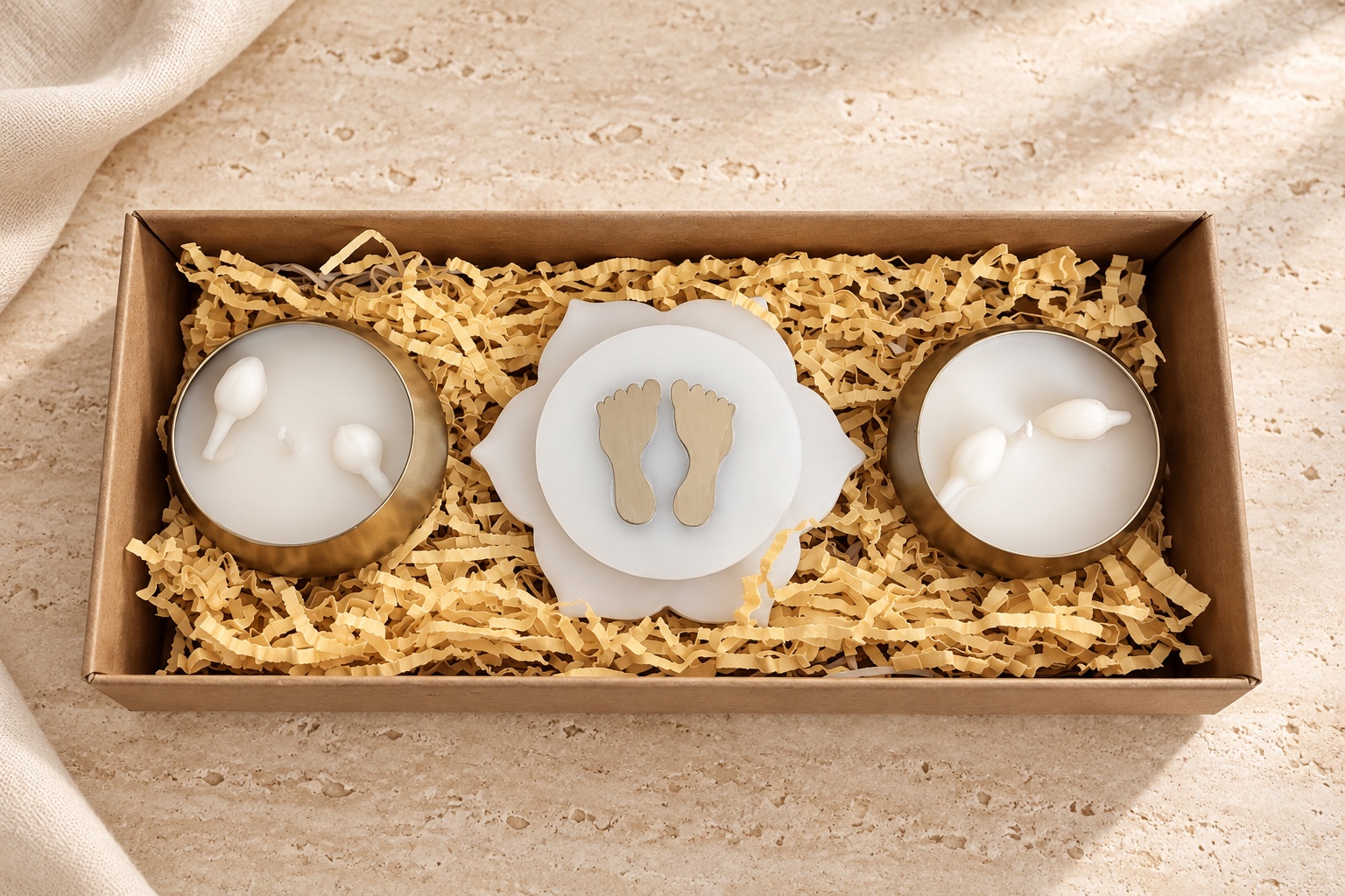 Two gold-tone candle bowls and an ivory centrepiece with golden footprints